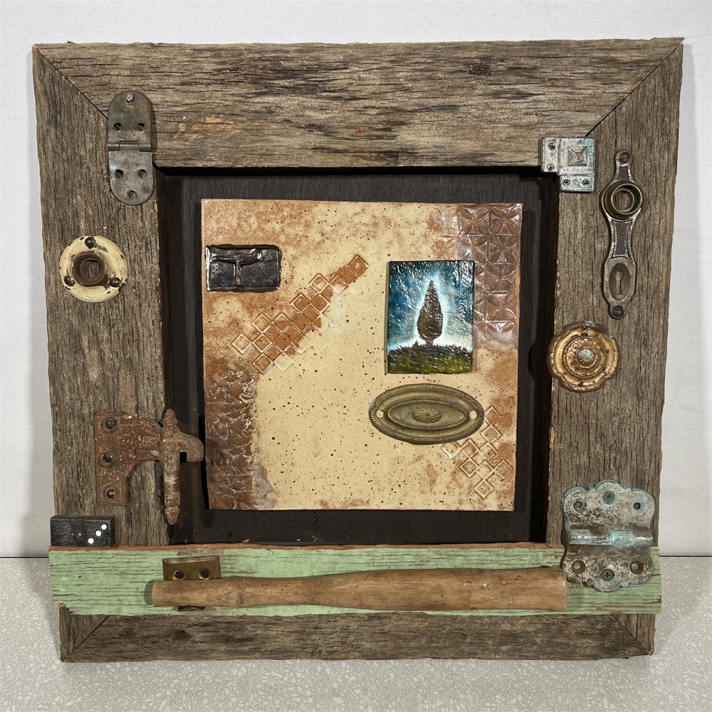 Wood frame and ceramic tile in the middle with ornate objects attached called "Patience Builds the Dream of Man" by Maya Hayes
